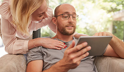 Married couple looking at a tablet device.