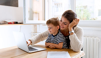 Mother and son looking at a laptop computer screen.