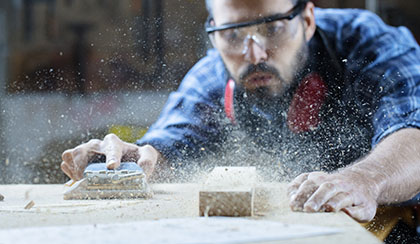 Craftsman using a sander on wood.